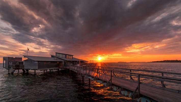 Long pier in Bjärred at sunset with dramatic sky | Lomma in Sweden