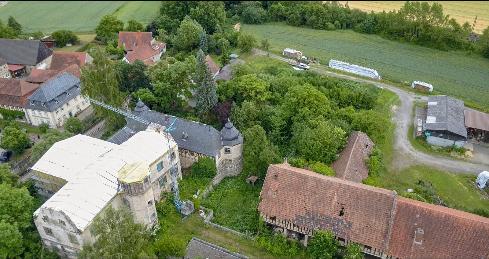 Blick von Nordwesten auf das Hauptgebäude des Rotenhan-Schlosses, hier mit wegen Brandschäden abgedecktem Dach. | Ebelsbach in Germany