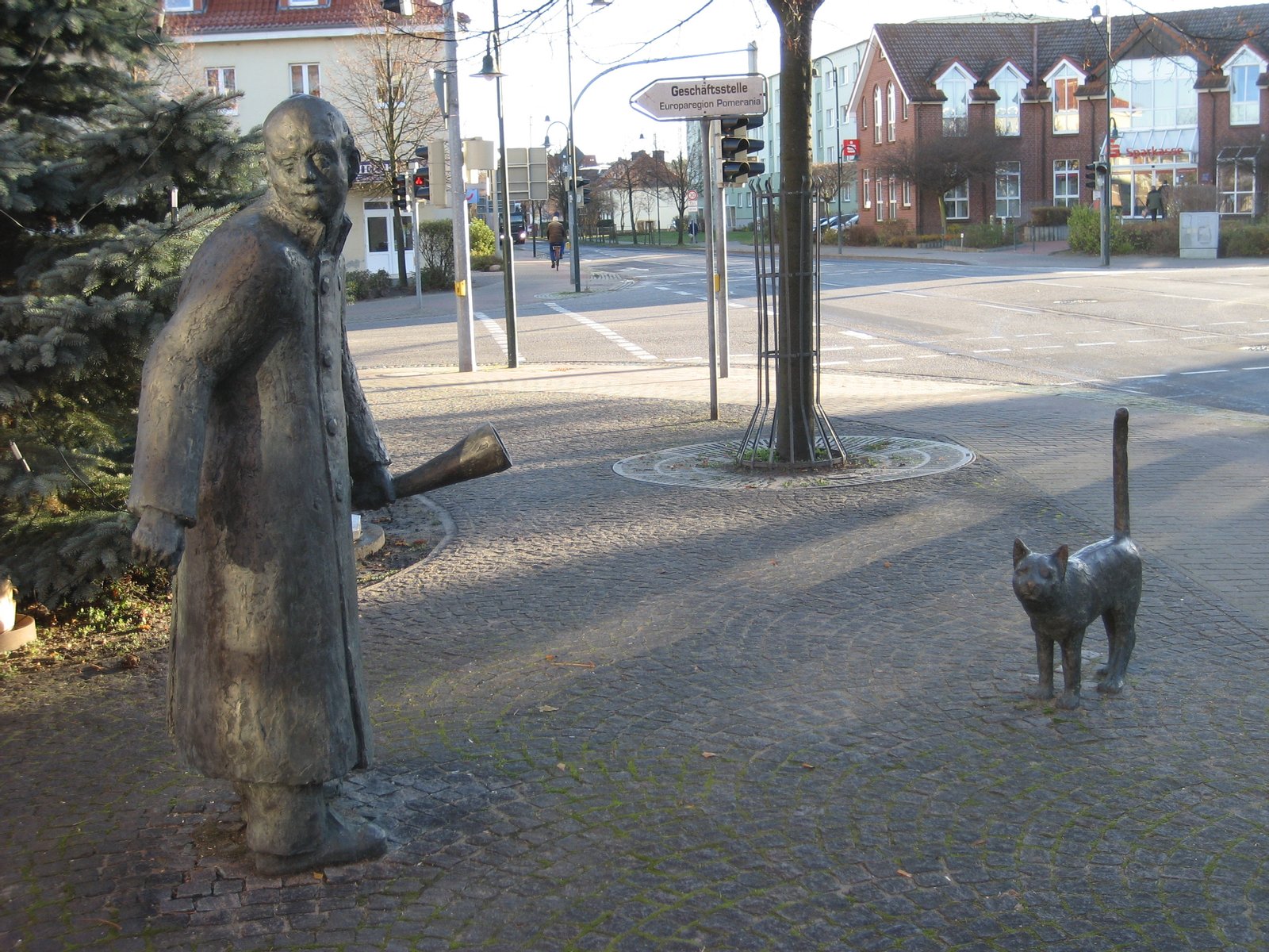 Nachtwächter Bartel mit Kater als Bronzeskulpturen vor dem Gebäude des Amtes Löcknitz-Penkun in der Chausseestraße 30. | Löcknitz in Germany