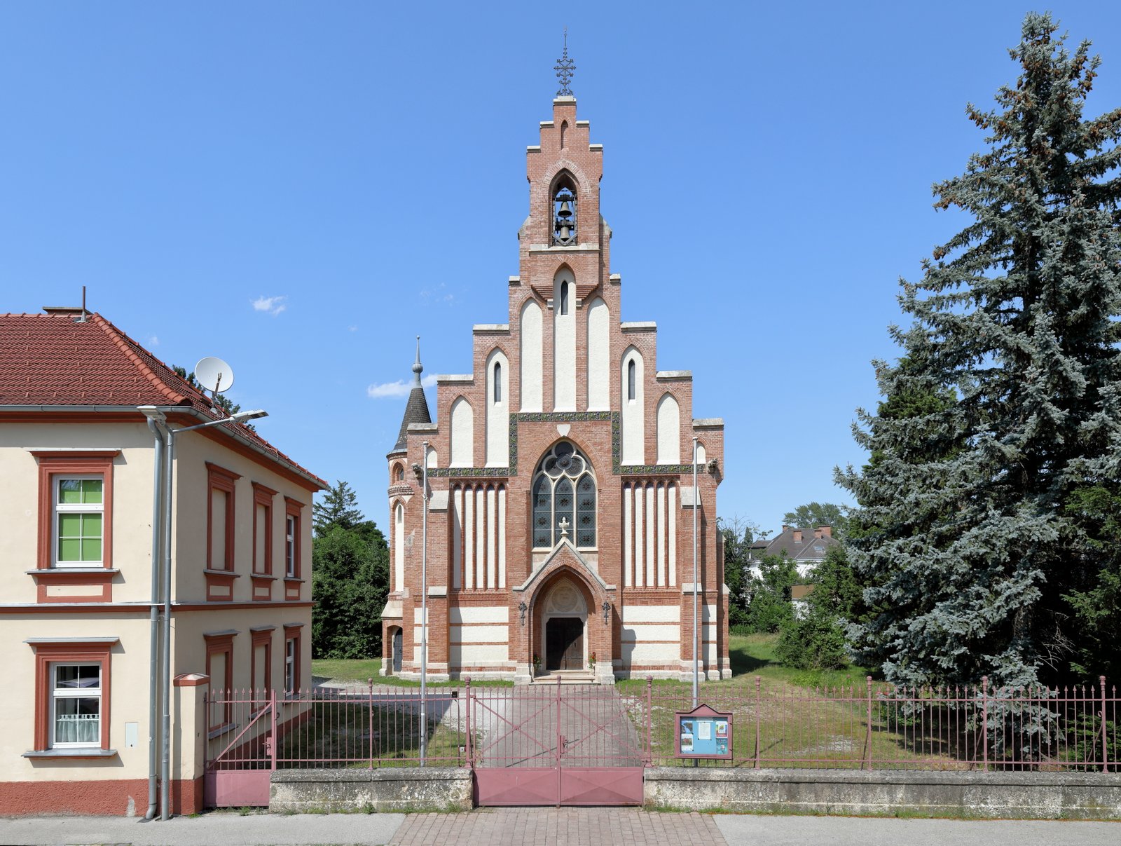 Südwestansicht der evangelischen Pfarrkirche in der niederösterreichischen Stadtgemeinde Neunkirchen. Der Backsteinbau im neugotischen Stil wurde 1862/63 nach Plänen des Wiener Architekten Hans (Johann) Petschnig (* 1821) errichtet. | Neunkirchen in Austria