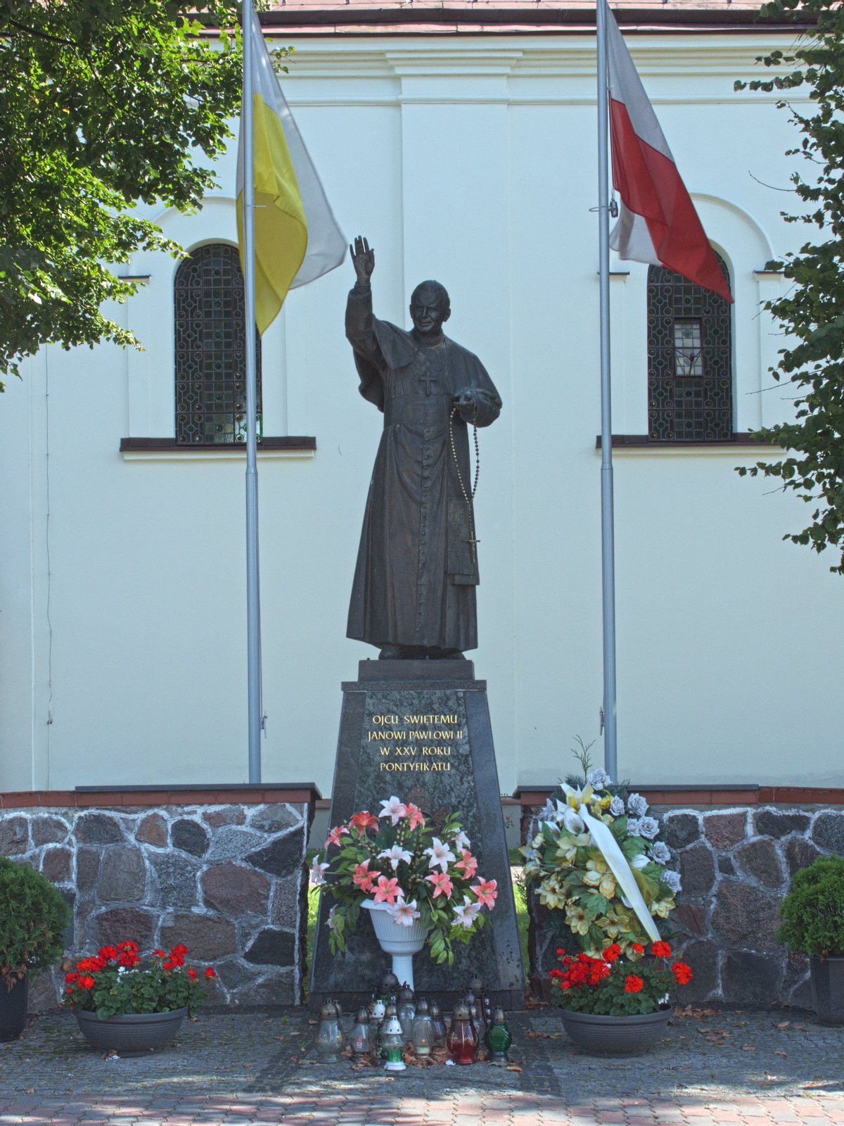 Pomnik Jana Pawła II wbudowany w ogrodzenie kościoła Wniebowzięcia NMP w Brańsku. | Brańsk in Poland