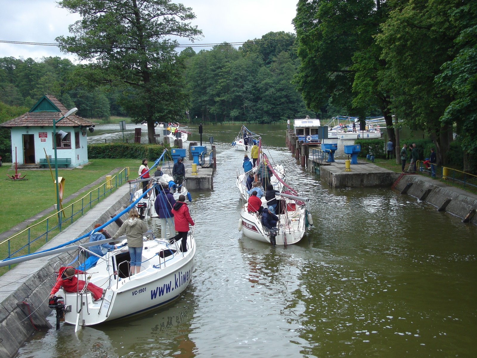 Śluza Guzianka. Jachty opuszczają śluzę, z prawej strony widoczne jednostki przygotowywujące się do wpłynięcia. | Ruciane-Nida in Poland
