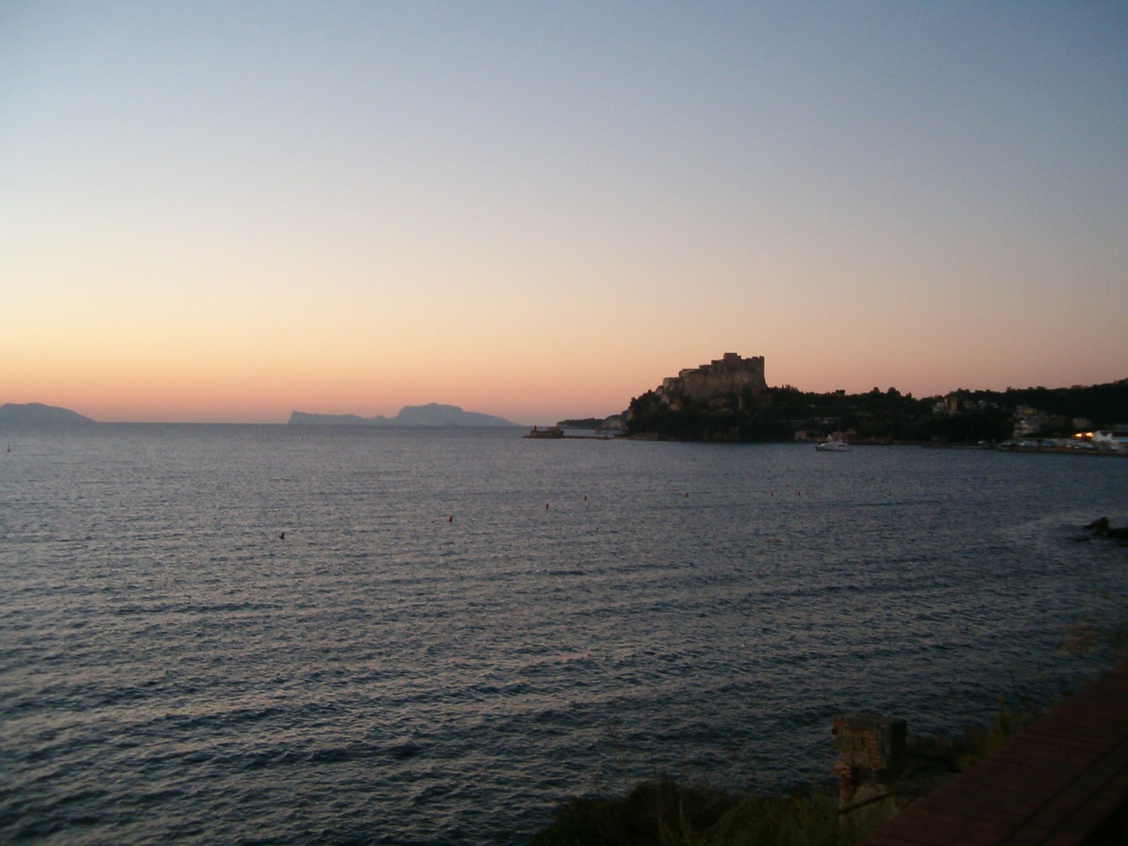 Comune di Bacoli: golfo di Pozzuoli, porto di Baia con il Castello Aragonese di Baia (al tramonto). All'orizzonte l'isola di Capri. | Bacoli in Italy
