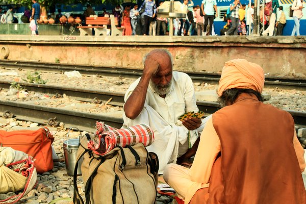 Ii am going to somewhere, it was 5:00 pm  and seen some people are sitting on the railway track (other side of station), me and my friend (saurabh sharma went close and saw that they are playing card game. one person looks very serious and i like this frame & click it. After that we talking them and tell that we taking a photo of yours. they tell  us if they know that photo click, they will smile but i told him that i like this frame, so i click.
we are gone to our place. 

thanks for them. | Gurugram in India