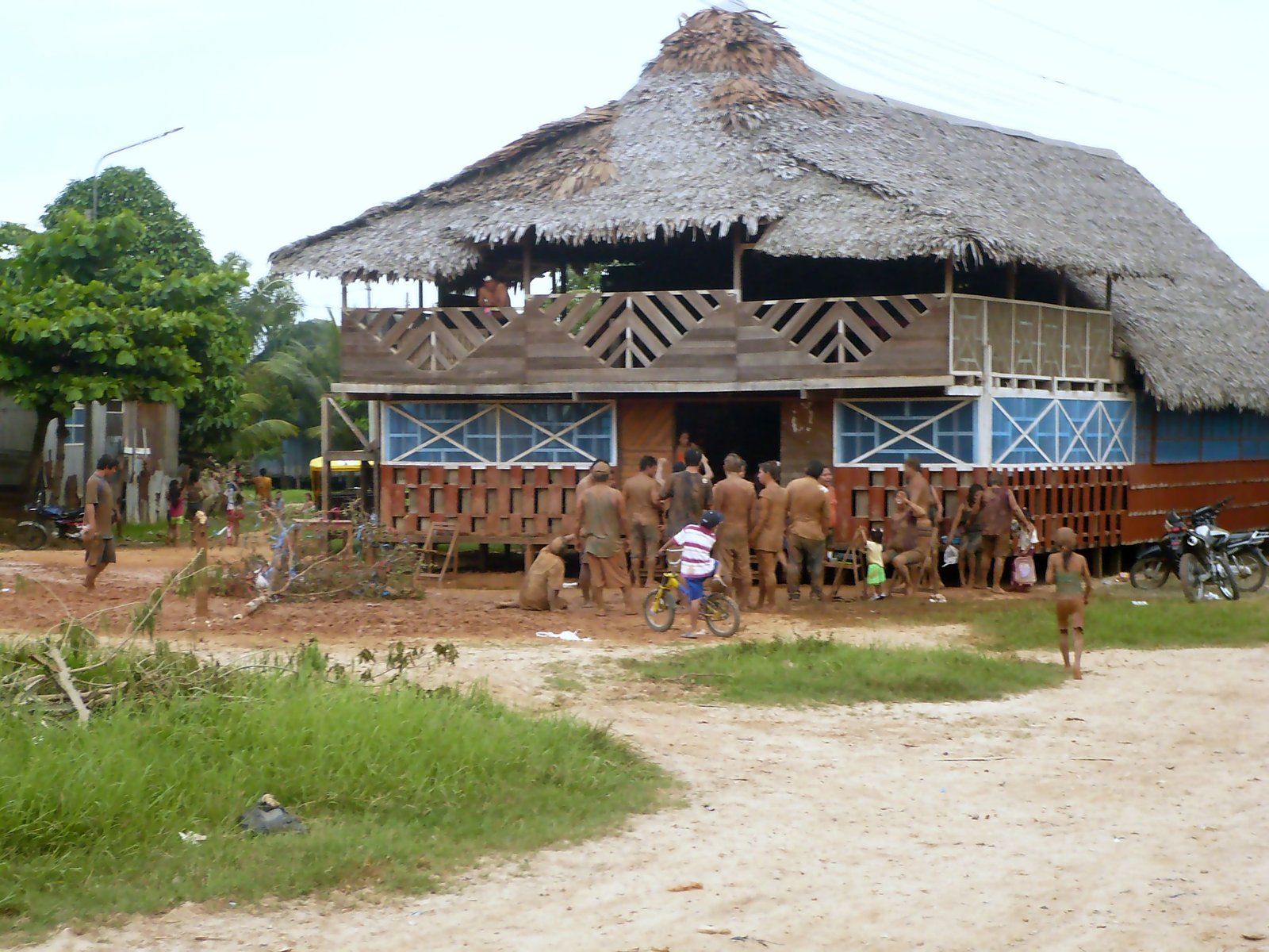 Vista de una de las actividades que hacen en carnavales. al fondo se observa una maloca y al frente ellos embarrándose por esta festividad. | Pucallpa in Peru