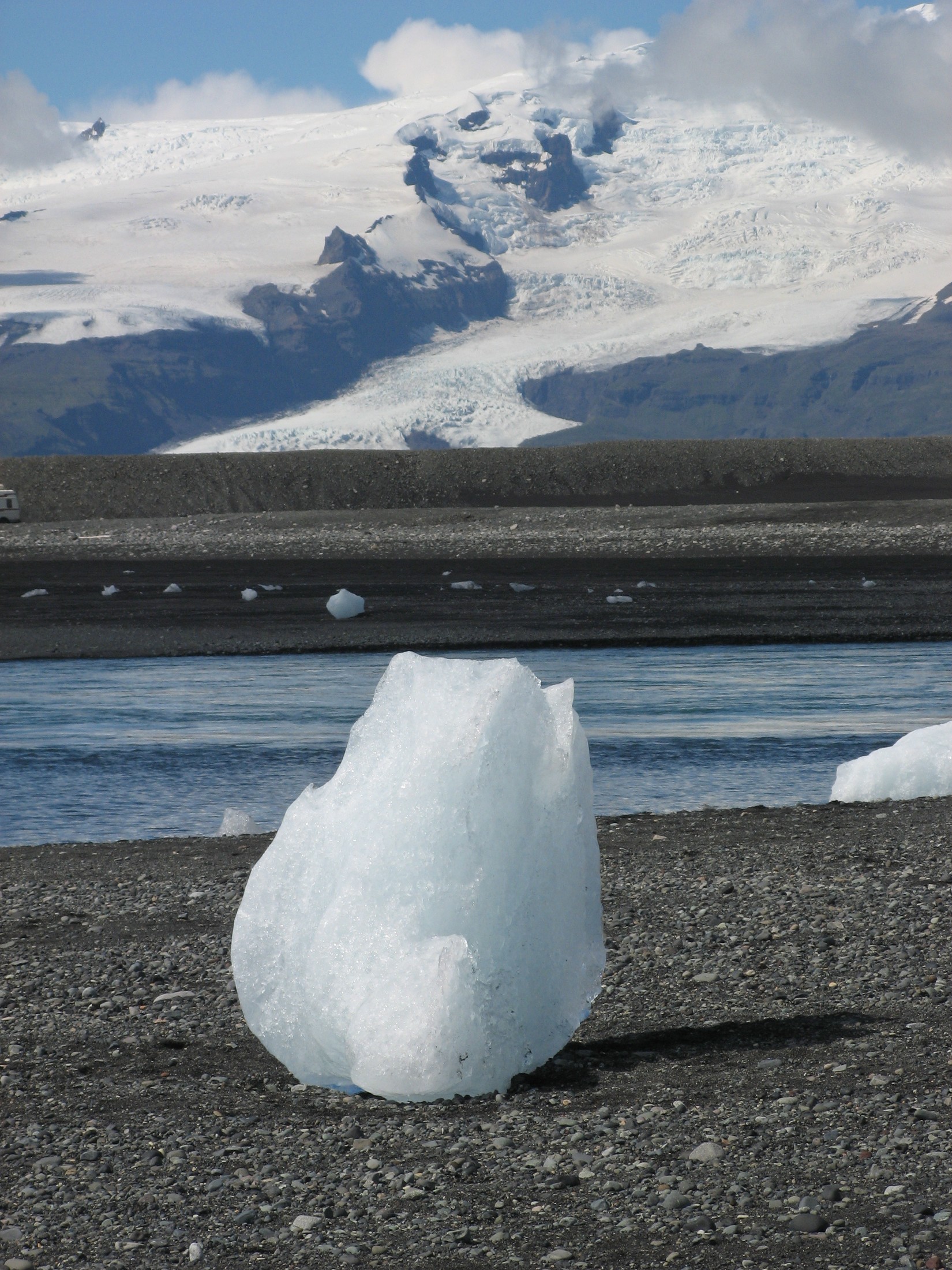 An iceberg near Jökulsárlón with Öræfajökull and its outlet glacier Hrútárjökull in the background. Öræfajökull is the southernmost tip of Vatnajökull. The iceberg came from Vatnajökull, as well as the other icebergs in Jökulsárlón. | Diamond Beach in Iceland
